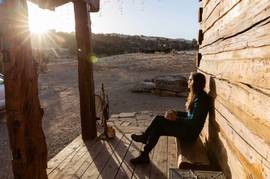 Woman sitting outside cabin at sunset at Canyons of the Ancients Guest Ranch in Mesa Verde Country, Colorado